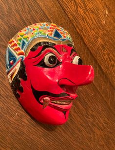 A vibrant and striking mask! Great colors. Elaborate detail. A wood carved mask for Javanese dance. Mask maker Ganuh Nugroho AdiNarimo is highlighted in an article (Javanese Klana 5/25/2017) in Second Face at maskmuseum.org Klana Sewandana (character) is the male antagonist in a love dance. In good condition with some minor chipping as shown in the photos. Enjoy! Traditional Carnival Masks And Prosthetics, Traditional Masks And Prosthetics For Carnival, Artistic Red Masks And Prosthetics For Festivals, Traditional Festival Masks And Prosthetics, Traditional Masks And Prosthetics For Masquerade Festivals, Traditional Masks For Masquerade And Festivals, Traditional Full Face Carnival Masks, Handmade Traditional Mask, Carved Mask