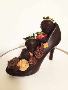 a chocolate shoe decorated with strawberries and flowers