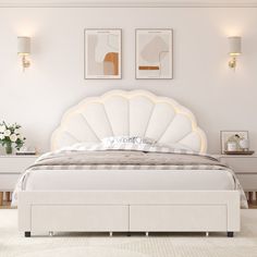 a large white bed sitting in a bedroom next to two framed pictures on the wall