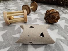 two wooden toys sitting on top of a bed next to each other with holes in them