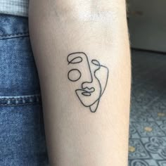 a person with a face tattoo on their arm