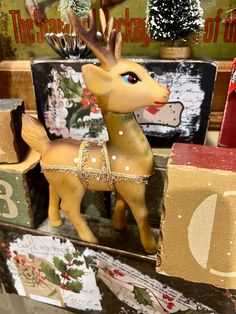 a deer figurine sitting on top of wooden blocks in front of christmas decorations