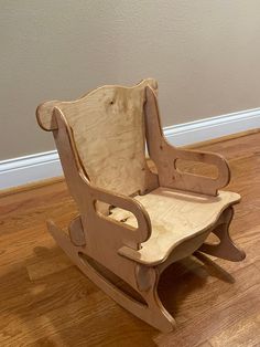 a wooden rocking chair sitting on top of a hard wood floor