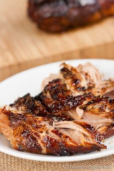 some meat is sitting on a white plate