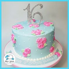 a blue and pink birthday cake with roses on it's side, the number sixteen