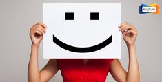 a woman holding up a white paper with a smiley face on it's face