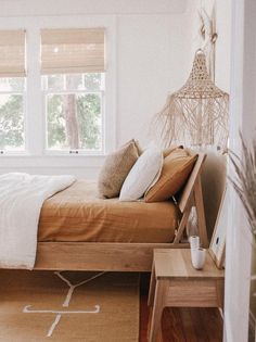 a bed sitting in a bedroom next to a window with wooden blinds on the windowsill