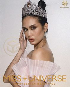 a woman wearing a tiara and holding her hand to her face with the words miss universe on it