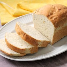 a white plate topped with sliced bread on top of a table