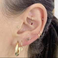 a close up of a person's ear with three different types of piercings