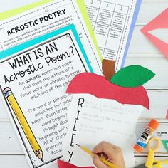 an apple with writing paper and scissors next to it