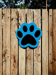 a blue and black paw print on the side of a wooden fence