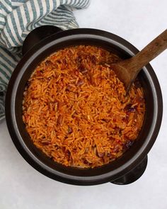 a wooden spoon in a bowl filled with rice