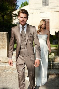 a man in a suit and tie walking down the street with a woman behind him