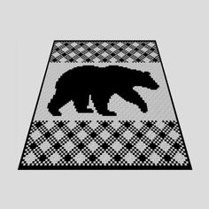 a black and white knitted bear rug on top of a gray floor with an argyle pattern