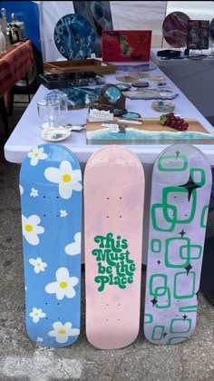 three skateboards sitting on top of a table next to each other at a festival