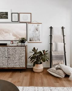 a living room filled with furniture and pictures on the wall next to a wooden floor