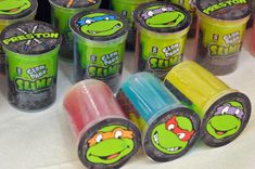 teenage mutant yogurt cups are lined up on a table with the tops painted in different colors