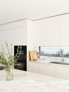 a kitchen with white cabinets and marble counter tops is seen in this image from the front view