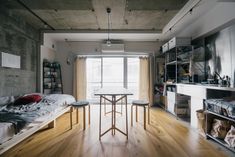 a room with a bed, table and shelves