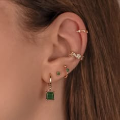 a close up of a person's ear with three different types of earrings on it