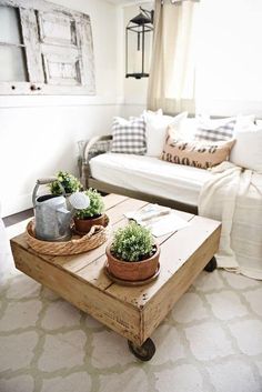 a living room with two couches, a coffee table and some potted plants