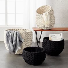 three black and white baskets sitting on top of a table