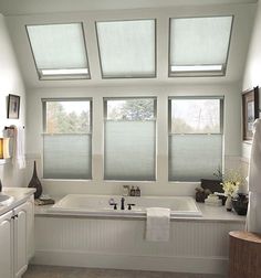 a bathroom with three windows and a bathtub