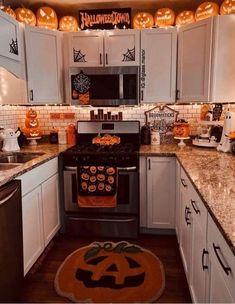 a kitchen decorated for halloween with pumpkins and decorations