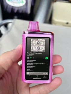 a person holding a pink electronic device in their left hand with money on it's screen