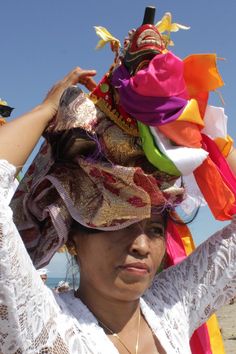 a woman wearing a colorful hat on top of her head with other items in the background