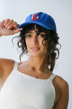 a woman in a white tank top and blue hat