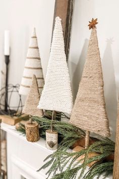 three small christmas trees sitting on top of a mantle