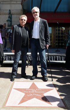 two men standing next to each other in front of a star