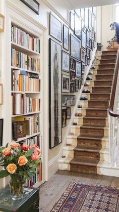 the stairs are lined with books and pictures