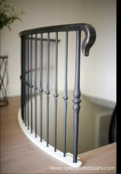 an iron hand rail on top of a wooden table next to a potted plant