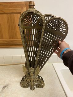 a person holding up a decorative item in their hand on top of a kitchen counter