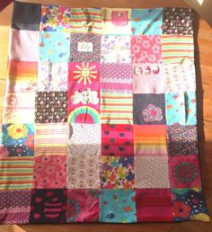 a colorful patchwork quilt sitting on top of a wooden floor