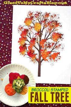 a paper plate with broccoli and leaves on it next to a fall tree