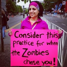 a woman holding a sign that says consider this practice for when the zombies chase you