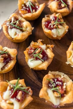 small appetizers with cranberry toppings on a wooden platter