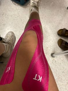 a person with pink tape on their leg