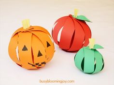 three paper pumpkins sitting next to each other