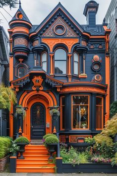 an orange and black house with lots of plants on the front porch, and stairs leading up to it