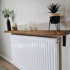 a radiator with some plants on top of it next to a white wall