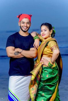 a man standing next to a woman on top of a beach