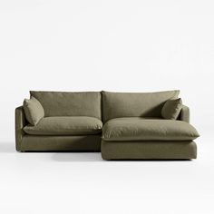 a couch with pillows on it sitting in front of a white wall