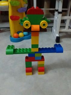 a toy that is made out of legos sitting on the floor in front of a play set