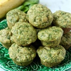 a pile of green muffins sitting on top of a green and white plate