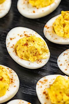 deviled eggs with mustard and seasoning sit on a baking tray ready to be cooked